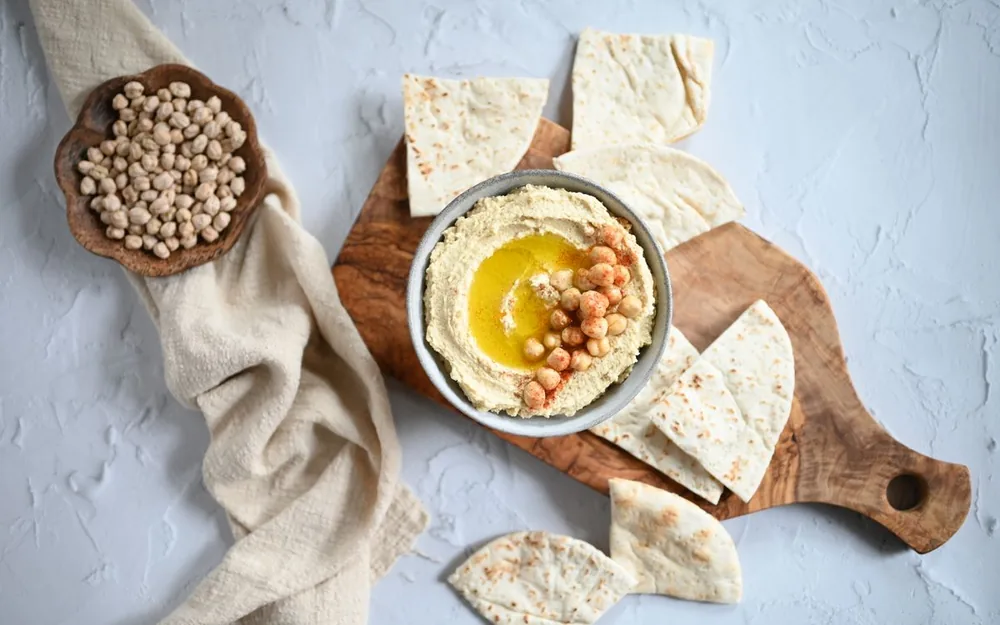 Hummus with olive oil, pita bread and chickpeas